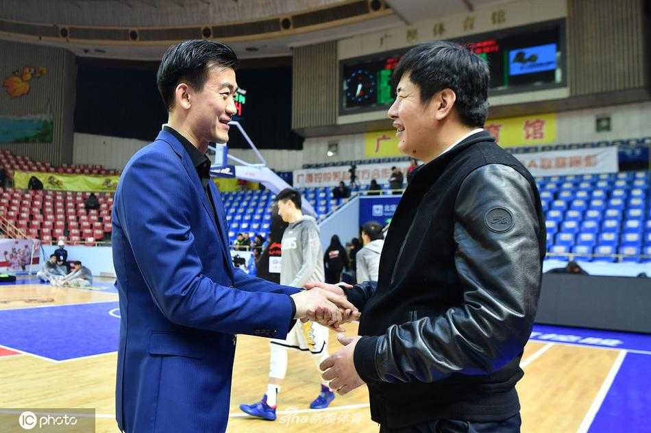王博在新闻发布会上神情严肃地分析比赛得失，面前摆放着麦克风和记录本，展现出职业教练的专注