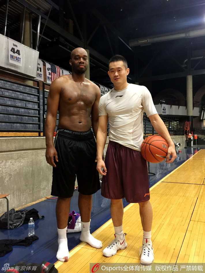 许家晗与NBA球星兰德里在训练场边亲切合影，笑容背后是东西方篮球文化的交流