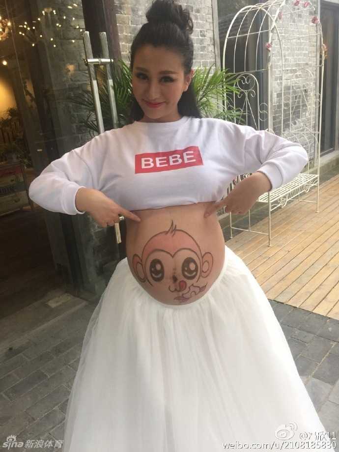 猴年孕味:同曦队长冯欣爱妻肚皮画猴,甜蜜写真尽显江南风情 孕妈低头凝视自己的肚皮,上面俏皮的猴子图案与甜美的微笑相映成趣,在江南水乡的柔美背景下,散发出母性的光辉与幸福。