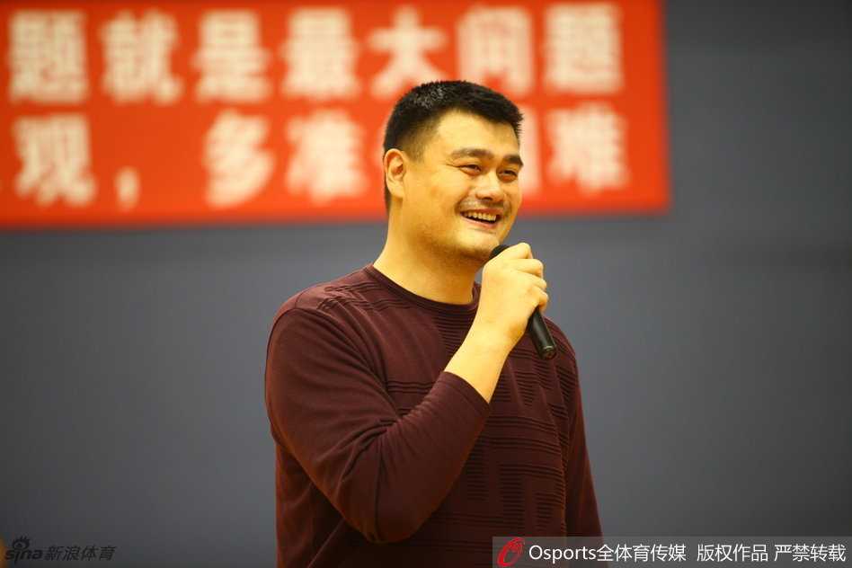 巨人的肩膀与少年的征途:姚明寄语国青国少,勇敢试错方能闪耀 篮球巨人姚明面带标志性微笑,微微俯身与一群满脸稚气却眼神热切的国少队小球员击掌互动,巨大的身高差构成了一幅关于传承与梦想的动人画面。