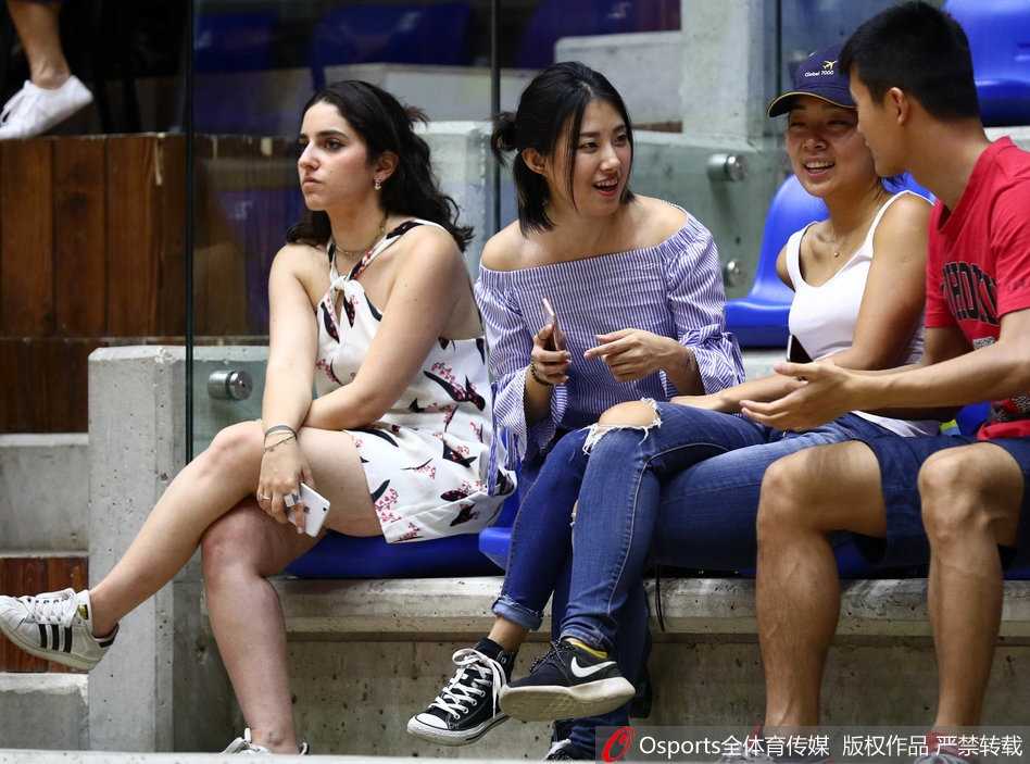 男篮亚洲杯险胜伊拉克 场边美女球迷与萌娃抢镜 几位球迷在场边热烈交谈,分析着比赛形势,手势丰富,神情投入